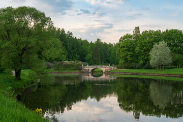 View of the Slavyanka River and the Viscontiev Bridge in the Pavlovsk Palace and Park Complex on a sunny summer day, Pavlovsk, Saint Petersburg, Russia
