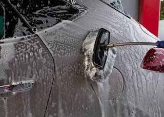 Cleaning the car with a brush and foam