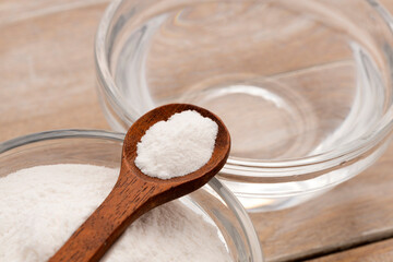 Baking soda powder in a spoon and bowl with mineral water - Healthy food