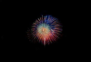 An isolated burst of colorful fireworks against a black background.