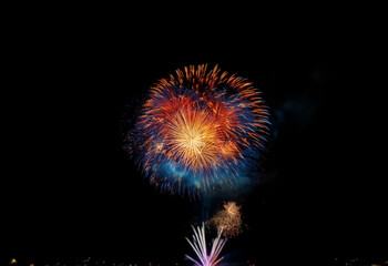Fototapeta premium A single, vibrant firework explodes against a dark, isolated background.