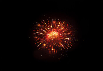 An isolated red and orange firework exploding against a black background.