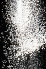 Abstract black and white background of pouring flour, space for text
