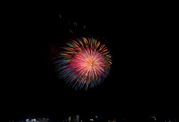 A colorful firework bursts against a dark, isolated background.