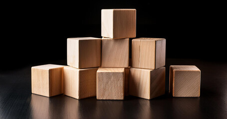 Obraz premium Wooden cubes on a dark background.