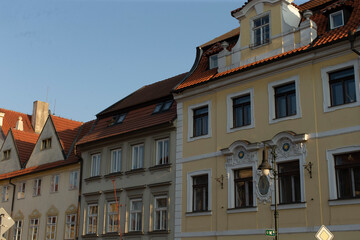 There is a long row of various buildings, each standing tall, with a street light positioned prominently right in front of them