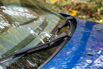 Generic blue car's front windshield wiper arms and blades, no people