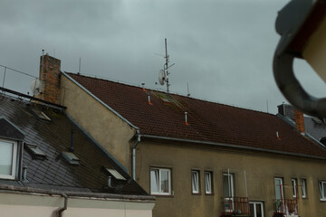 There is a charming building that features a vibrant red roof along with a classic chimney elegantly placed on top of it