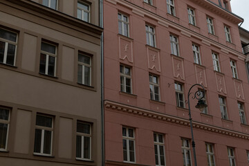 There stands a prominent building with numerous windows, and just in front of it, there is a street light illuminating the area