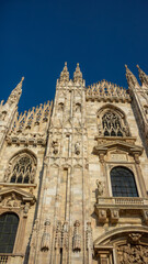 Fototapeta premium Exquisite Gothic architecture of the Milan Cathedral under a clear blue sky in the heart of Milan during midday