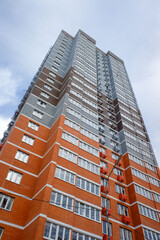 A tall brick building with a red and brown facade