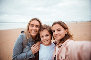 Obraz premium Family taking selfie on the beach during vacation