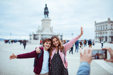 Happy siblings posing for photo in front of historical monument during vacation