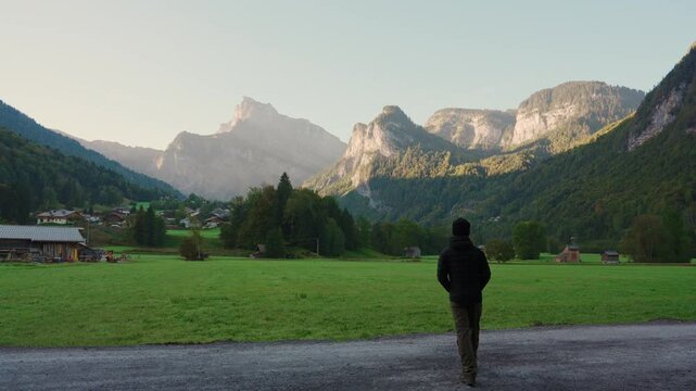 Male tourist enjoying with rustic village and mountain range in Giffre Valley at Sixt Fer a Cheval, France