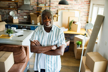 Portrait of a senior black man in apartment filled with moving boxes