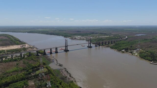 Drone view of Justo Jose de urquiza bridge above the wide Parana Guazu river, a vast waterway, Buenos Aires Argentina. Flying forward to the bridge