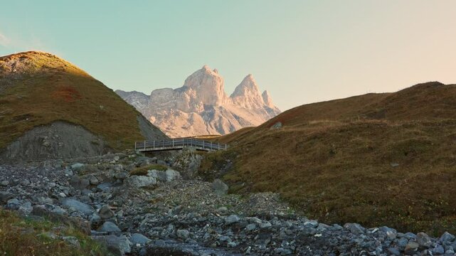 Landscape of iconic three peak mountain and stream flowing in Aiguilles d Arves among French Alps