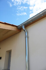 Gouttière en zinc gris sur la façade de la maison neuve