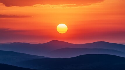 A vibrant sunset casts an orange glow over a silhouette of rolling hills, creating a dramatic and peaceful scene.