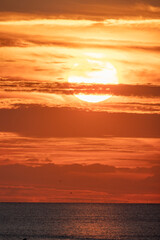 Naklejka premium A stunning sunset casts golden hues over calm ocean waters, creating serene landscapes that inspire peace