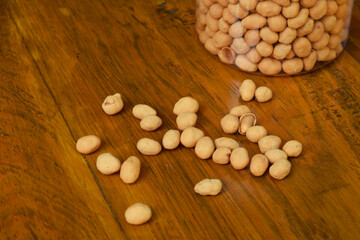 Closeup photo of some dried atomic Nuts and food storage or jar on wooden table