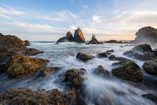 Wave water flowing into the rocky shore of Camel Rock, Bermagui, Australia.