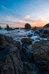 Beautiful sunset view on the rocky beach shore.