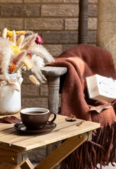 Cup of coffee on wooden table outdoors on porch