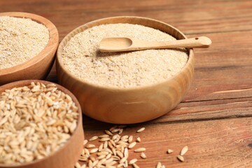 Oat bran and grains on wooden table, closeup