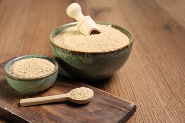 Oat bran in bowls, spoon and scoop on wooden table