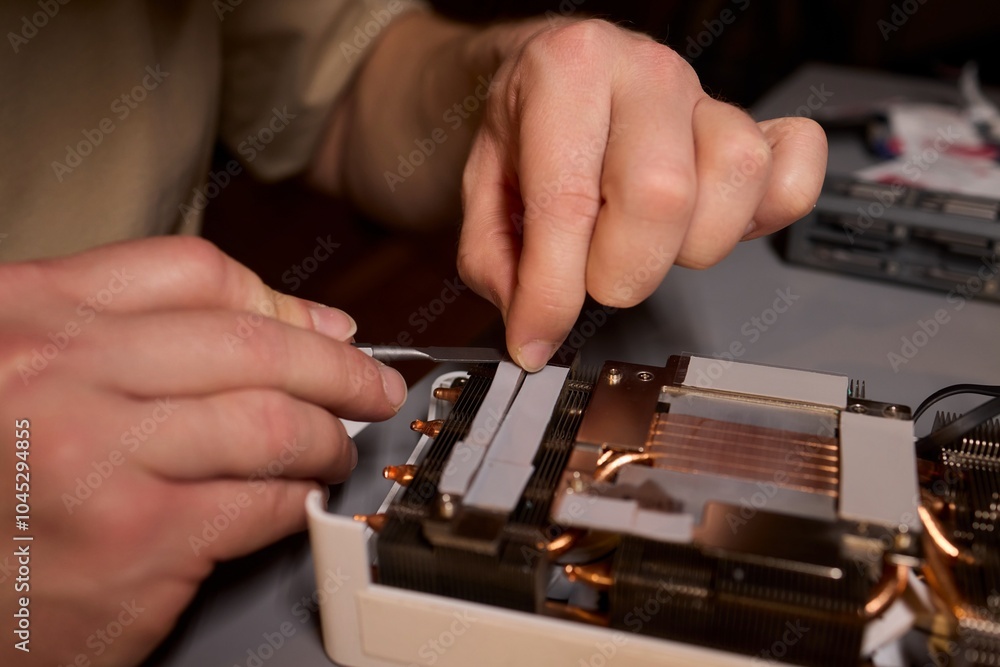 Aufkleber hand repairing a graphics card through the application of thermal paste for better performance