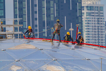 Male workers rope access height safety connecting with eight knots safety harness construction site...