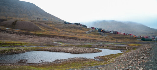 Trains traverse the stunning landscape of Svalbard during overcast weather