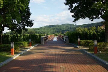 Jade Gol Bridge crosses over Yeongnam area in South Korea, surrounded by greenery and a blue sky © Wirestock