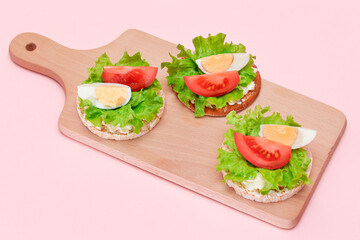 Rice Cake Sandwiches with Tomato, Lettuce and Egg on Wooden Cutting Board. Easy Breakfast. Diet Food. Quick and Healthy Sandwiches. Crispbread with Tasty Filling. Healthy Dietary Snack