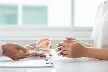 woman consults dentist about her toothache for treatment in dental clinic and dentist gives advice...