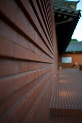 Fototapeta premium Side shot of Red brick wall of a traditional pagoda showcasing intricate architectural design