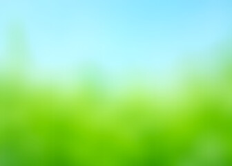 Green grass and blue sky in an abstract background with a blurred effect.