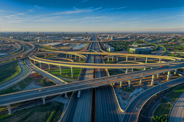 Aerial view Interstate 10 or Katy freeway with massive intersection, stack interchange, elevated road junction overpass in daytime with cloud blue sky. Aerial metropolitan area of Katy, Texas, US.
