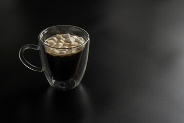 cup of coffee with marshmallow on the black background 