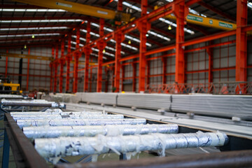 A large industrial building with a lot of pipes and metal. The pipes are white and the building is orange