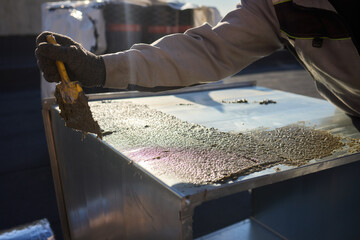 A person skillfully applying aluminum foil in a construction setting for insulation purposes