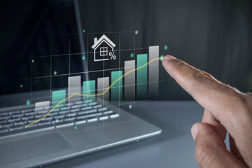 Hand pointing to a virtual graph. House price rising up or real estate property growth concept.