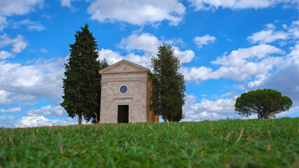 A charming rural chapel under the expansive Tuscan skies in Italy during midday