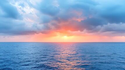 Obraz premium Breathtaking view of a serene ocean at sunset with dramatic sky reflections and calm waters
