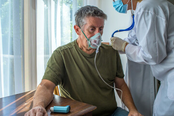 Oxygen face mask is placed on a man with breathing difficulty due to his lung disease. Covid-19,...