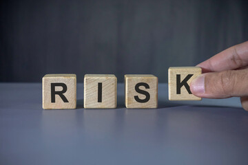 Hand holding wooden block with risk word. Risk management concept.