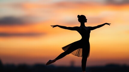 Silhouette of a graceful ballet dancer in an elegant pose against a vibrant sunset sky, capturing beauty and movement.