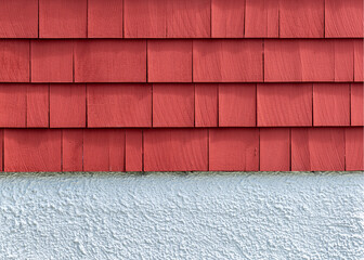 Close-Up of red wood shingles above textured white stucco wall on a house in Brighton, Massachusetts, USA