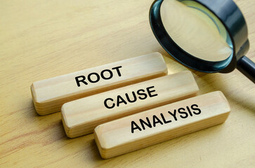 Root Cause Analysis text on wooden blocks with magnifying glass background